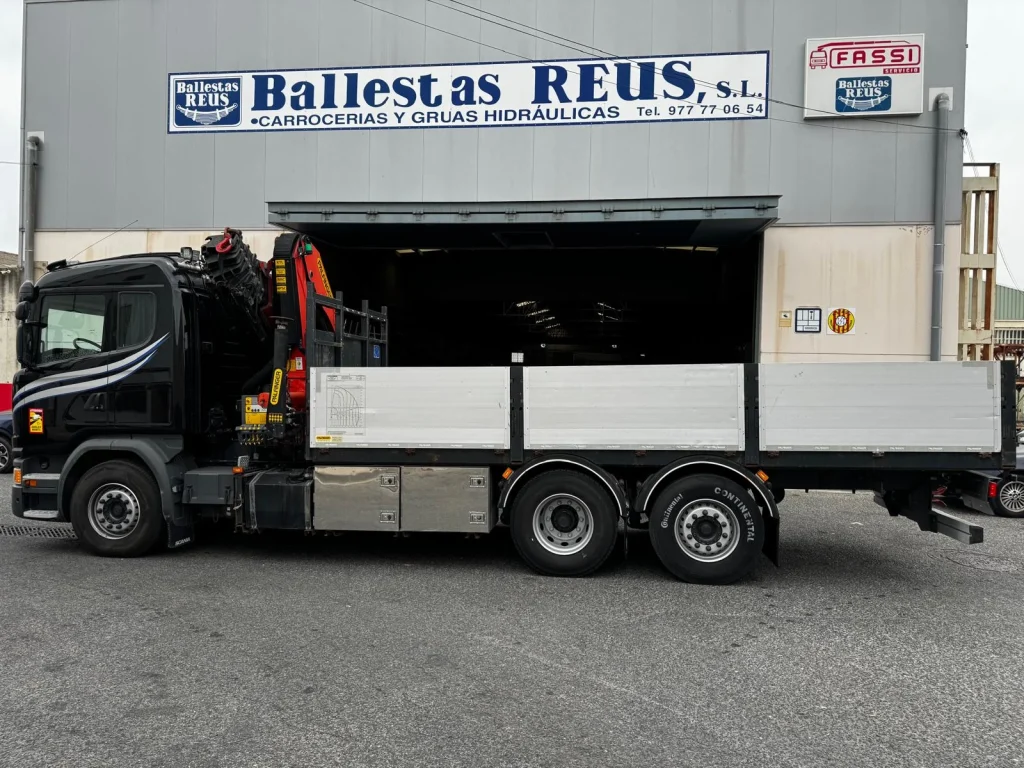 scania g490 con grúa palfinger, vista lateral frente a las instalaciones de ballestas reus